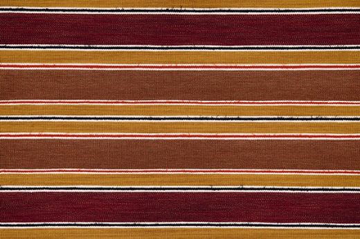A striped woven fabric in rich red, terracotta tones with small stripes of orange and navy.