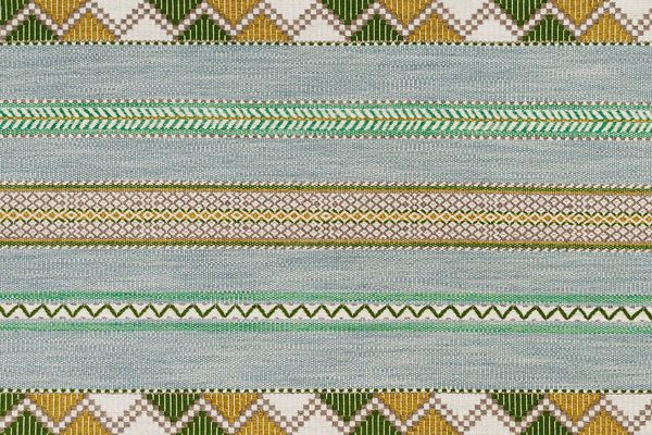 Woven fabric in green and blue tone. Has zig zag motif stripes running horizonal.