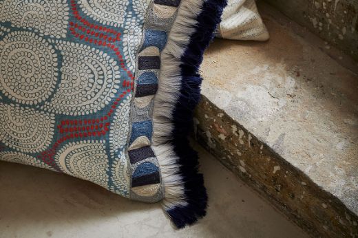 Cushion with Pop Art Border Trim, Circles, and Jute Texture, featuring Ombre Fringe Edge in Indigo Blue and Azteque Coral Linen Fabric. Photography by Christopher Horwood.