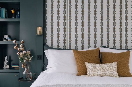 Sophisticated, cosy masculine bedroom featuring a fabric-panelled headboard in the Chicago Geometric Stripe design, with bold stripes in tobacco colorway, designed by Kitesgrove Design.