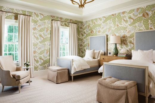 A bedroom with two single beds and botanical, floral, patterned wallpaper by Christopher Farr Cloth in Carnival Sky