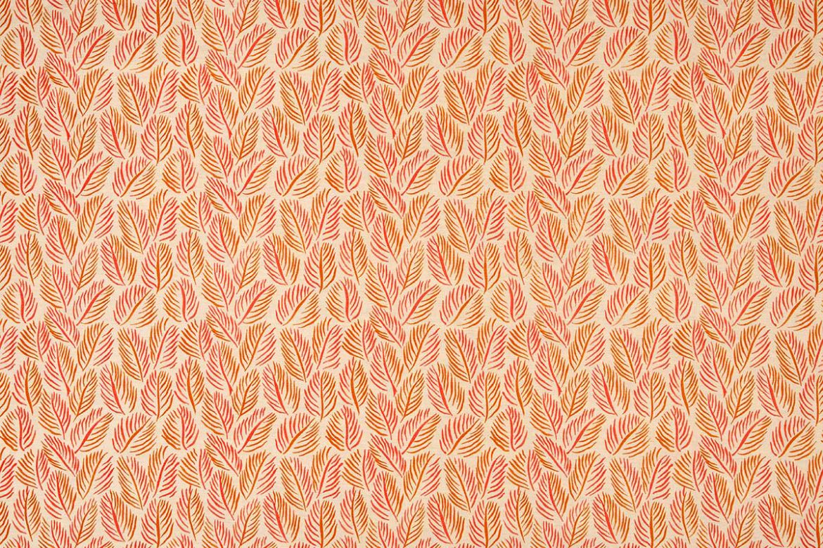 Armatures Feuilles luxury printed linen fabric in a small leaf print used for upholstering a stylish armchair, featuring soft orange and natural tones