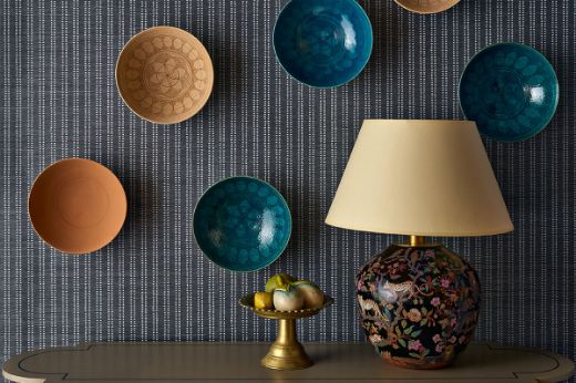 Image of Algonquin grass cloth on a wall with plates hung up and a lamp in front