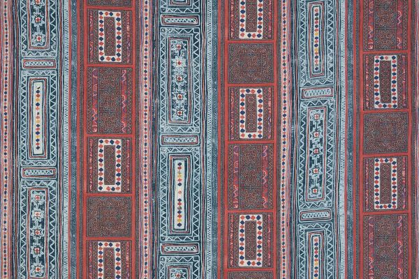 A vibrant textile with vertical stripes and geometric patterns featuring diamonds, florals, and intricate borders in red, blue, white, and yellow.