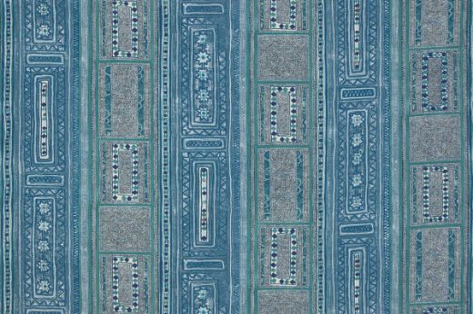 A vibrant textile with vertical stripes and geometric patterns featuring diamonds, florals, and intricate borders in tones of blues and indigos