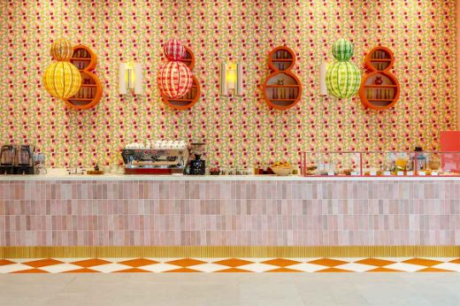 Modern interior featuring a counter with a backdrop of Cactus Flower Printed Wallpaper in Limone yellow. Designed by North 5 Consulting Group and Popus Editions, this vibrant space combines bold, contemporary design with a playful, artistic floral pattern.
