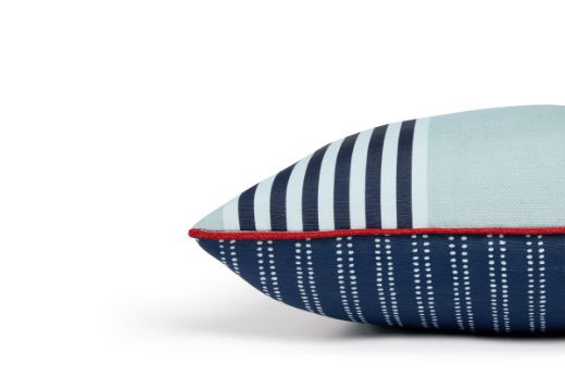 Side view of The Hudson Stripe Outdoor Cushion featuring a bold and intricate stripe design in Azzurro blue and white, with red piping offering a contrast for a modern yet timeless look for outdoor spaces.