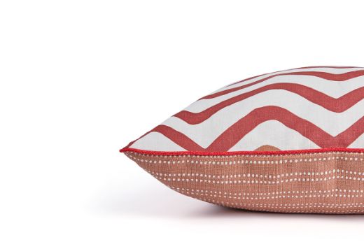 Side view of Rick Rack cushion showing the terracotta embroidered front, Algonquin Stripe back, and contrasting Rosso Vertelli red piping along the edge.